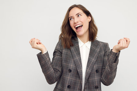 Portrait of smiling businesswoman looking sideways having fun and being happy isolated on white background.の写真素材