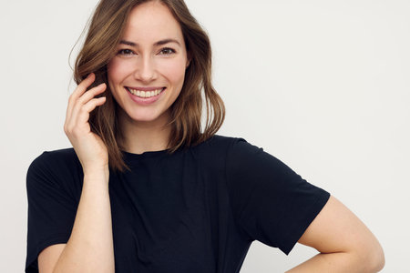 Portrait of a happy smiling brunette woman looking beautiful standing isolated on white background. Young female girl with a perfect big smile, dentist smileの写真素材