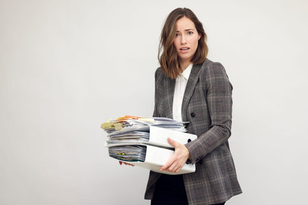 Stressed and insufficient female worker and business woman holding paperwork. Looking depressed in...