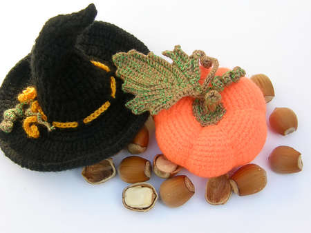 knitted witch hat with pumpkin and nuts on a white background.の写真素材