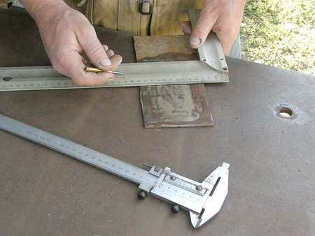 marking the metal workpiece with a bench square and a caliperの写真素材