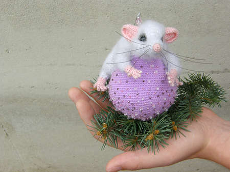 Gray toy mouse on a lilac ball and fir branches. new Year.の写真素材