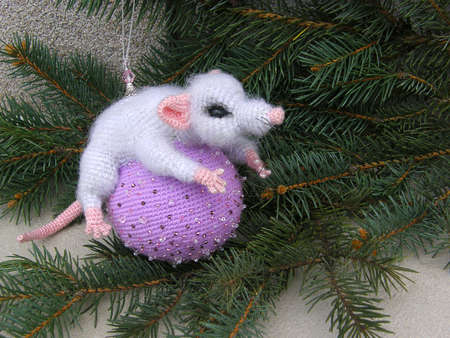Gray toy mouse on a lilac ball and fir branches. new Year.の写真素材