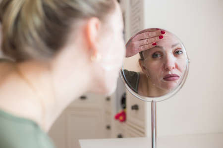 Cosmetic face mask and girl look in the mirrorの写真素材
