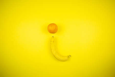 Fruit banana and orange on a yellow backgroundの写真素材