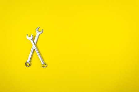 Two wrenches on a yellow background