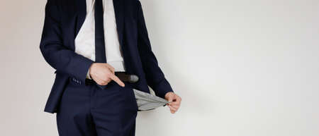 A man in a business suit turned his pockets inside out. Financial crisis. Bankruptcy in business. An entrepreneur without money.の写真素材