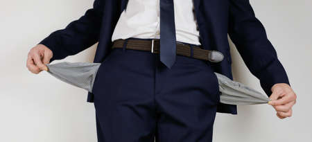 A man in a business suit turned his pockets inside out. Financial crisis. Bankruptcy in business. An entrepreneur without money.の写真素材
