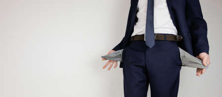 A man in a business suit turned his pockets inside out. Financial crisis. Bankruptcy in business. An entrepreneur without money.の写真素材