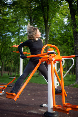 The girl on the summer sports ground does sports exercises on the stepper. Healthy lifestyle....