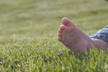 bare baby foot in the grassの写真素材