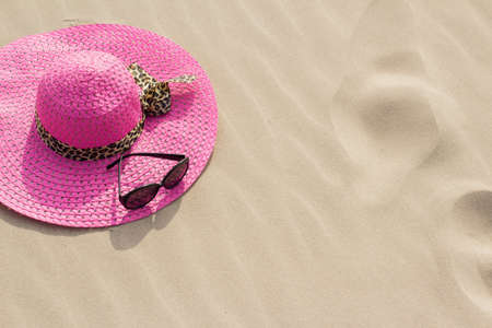 Summer hat and sunglasses on sand  の写真素材