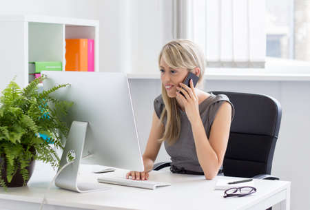 Woman talking on phone in the office  の写真素材