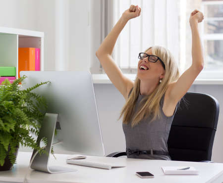 Happy young businesswoman enjoying success at work  の写真素材