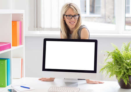 Creative young woman showing blank presentation on computer screen  の写真素材