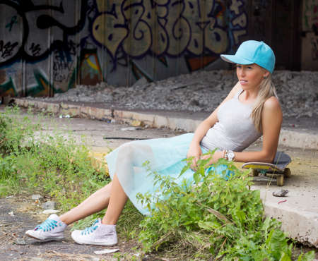 Trendy young girl resting on skateboardの写真素材