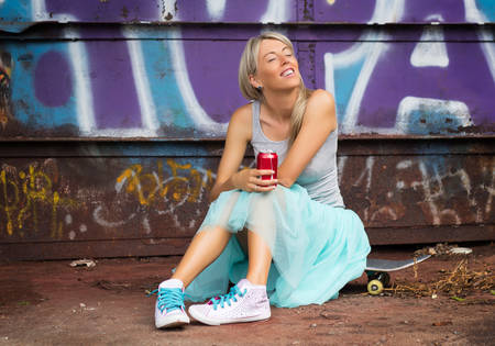 Candid portrait of young trendy girl with skateboardの写真素材