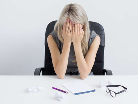 Overworked young woman sleeping on deskの写真素材