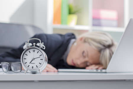Exhausted woman sleeping in front of computerの写真素材