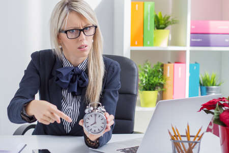 Frustrated business woman is angry about being late at workの写真素材