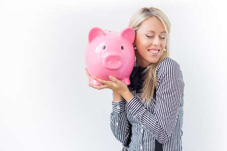 Happy woman holding pink piggy bankの写真素材