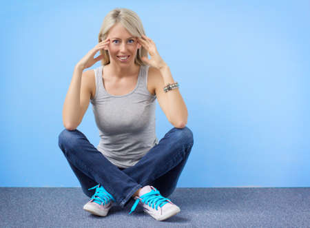 Young hipster girl sitting on the floor indoorsの写真素材