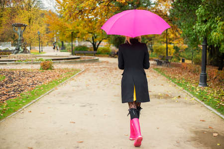Woman walking in park in autumnの写真素材
