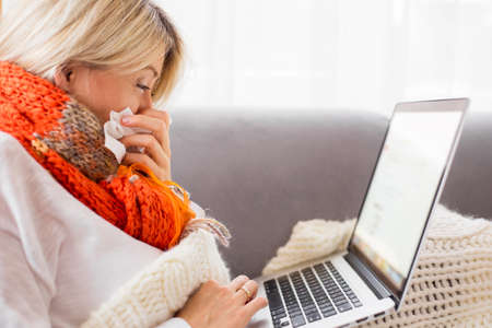 Sick woman working from homeの写真素材