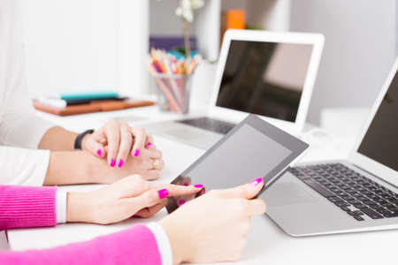 Colleagues using tech gadgets at workの写真素材