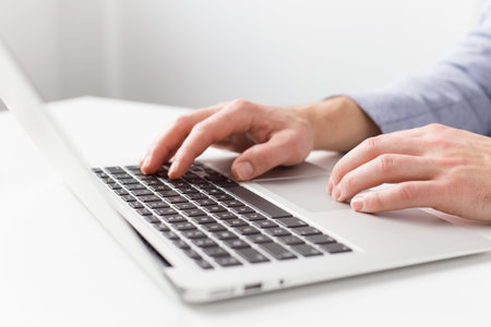 Close-up photo of man working with laptop computer