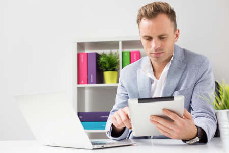 Young businessman working with tablet computer in officeの写真素材