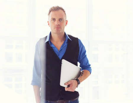 Young creative man holding laptop computerの写真素材