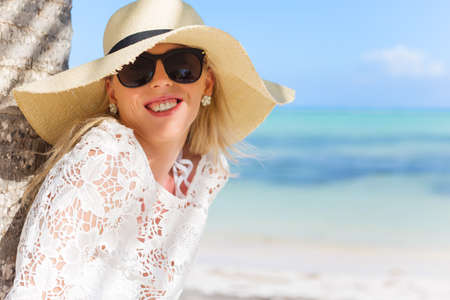 Smiling woman standing under palm treeの写真素材