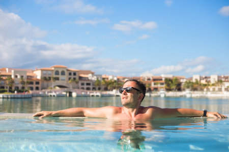 Handsome man relaxing in the swimming pool