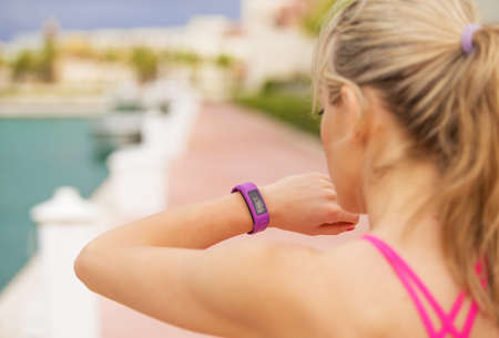 Woman looking at her smartwatch during workoutの写真素材