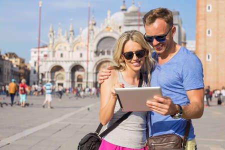 Tourists using tablet computer while sightseeing in Veniceの写真素材