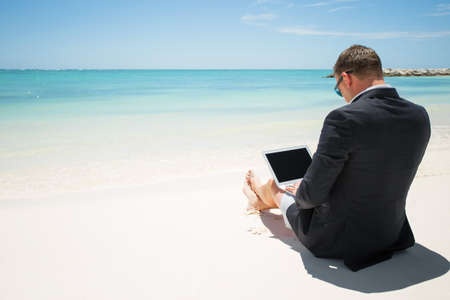 Businessman with computer on the beachの写真素材