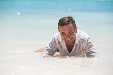 Handsome man having fun in wet shirtの写真素材