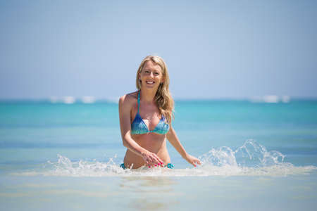 Smiling woman coming out of waterの写真素材