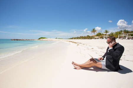 Busy businessman working on the beachの写真素材