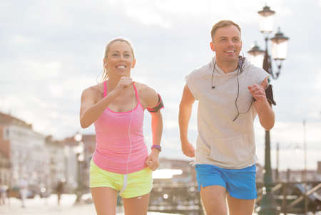 Happy couple running together in the cityの写真素材