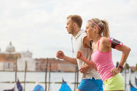 Woman and man running outdoors togetherの写真素材