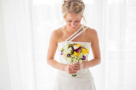 Bride looking down at her flowersの写真素材