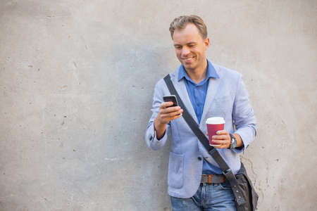 Man looking at his phone and smilingの写真素材