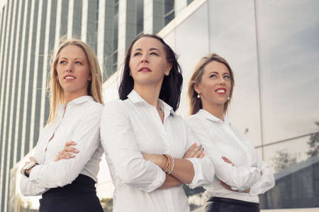 Corporate women standing with crossed handsの写真素材