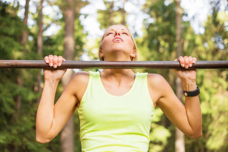 Active and young woman doing pullupsの写真素材
