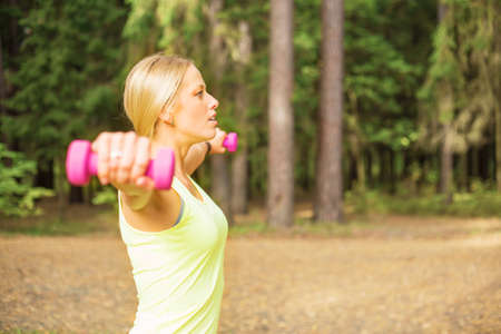 Active woman working out with dumbbellsの写真素材