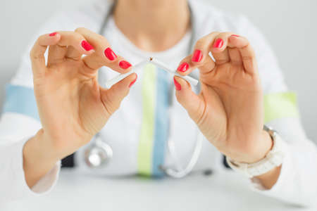 Doctor breaking a cigaretteの写真素材