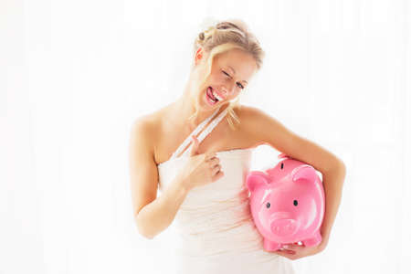 Bride with piggy bank showing thumbs upの写真素材