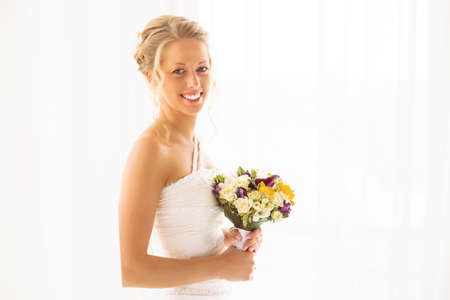 Happy bride holding her wedding flowersの写真素材